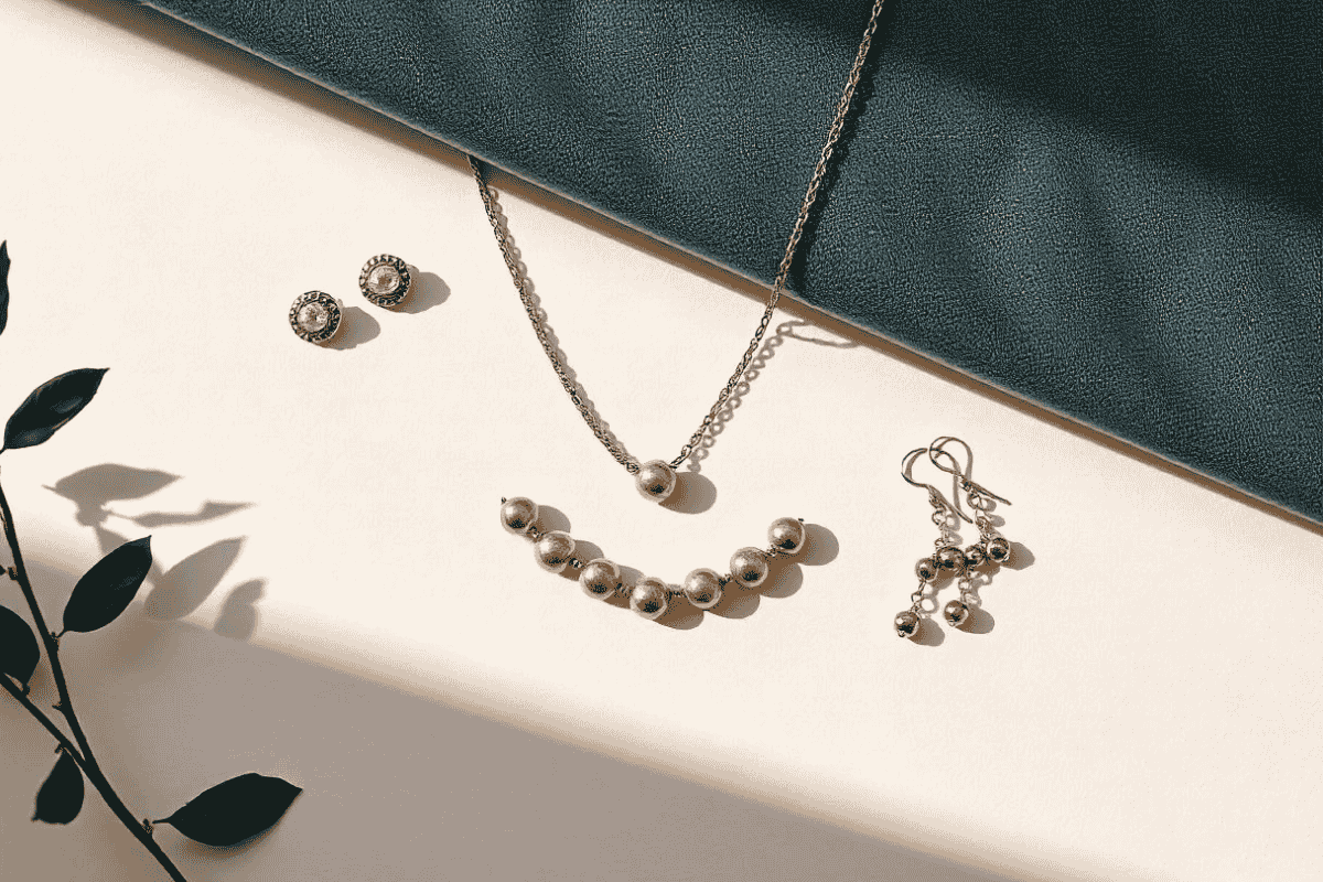 Flat lay of elegant jewelry for modern working women, including stud earrings, a statement necklace, bracelets, and dangle earrings on a professional background.